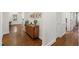 Hallway featuring hardwood floors, white walls, and a wooden dresser with decorative items at 2707 Anderson Drive Dr, Raleigh, NC 27608