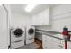 Functional laundry room with modern appliances, storage cabinets, and a convenient sink for efficient chores at 2707 Anderson Drive Dr, Raleigh, NC 27608