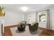 Cozy living room with hardwood floors, a neutral rug, and comfortable green chairs around a round table at 2707 Anderson Drive Dr, Raleigh, NC 27608