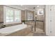 Elegant bathroom featuring a soaking tub, glass-enclosed shower, and neutral tile finishes at 2707 Anderson Drive Dr, Raleigh, NC 27608