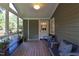 Inviting screened porch with wooden bench seating, plants, and views of the surrounding greenery at 2707 Anderson Drive Dr, Raleigh, NC 27608