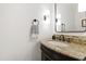 Chic powder room featuring granite countertop, dark fixtures, and modern lighting, adding a touch of elegance at 2707 Anderson Drive Dr, Raleigh, NC 27608