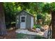 Charming storage shed nestled in a lush backyard with a stone pathway and surrounding greenery at 2707 Anderson Drive Dr, Raleigh, NC 27608