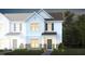 Charming two-story townhome with white siding, brick accents, and a welcoming front porch at 276 Fosterton Cottage Way, Raleigh, NC 27603