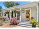 Inviting front porch with rocking chairs, hanging ferns, and a bright wood front door at 2816 Keck Dr, Burlington, NC 27215