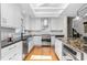 Bright kitchen featuring white cabinets, a skylight, stainless steel appliances, and hardwood flooring at 2816 Keck Dr, Burlington, NC 27215