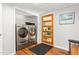 Modern laundry room with wood floors, front-load washer/dryer, and backyard access at 2816 Keck Dr, Burlington, NC 27215