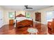 Bedroom with hardwood floors, four-poster bed, ceiling fan, and bright natural light at 2816 Keck Dr, Burlington, NC 27215