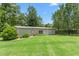 Exterior of an outbuilding, beautifully landscaped with green lawn and mature trees at 2816 Keck Dr, Burlington, NC 27215