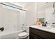 Clean bathroom with shower-tub combo, white tiling and dark vanity at 2998 Matthews Mill Pond Rd, Angier, NC 27501