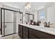 Modern bathroom with a double vanity, and a glass enclosed shower with dark hardware at 2998 Matthews Mill Pond Rd, Angier, NC 27501
