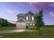 Charming two-story home featuring a neutral exterior, attached garage, and well-maintained lawn at sunset at 2998 Matthews Mill Pond Rd, Angier, NC 27501