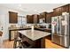 Well-lit kitchen features an island, stainless steel appliances, and brown cabinetry at 2998 Matthews Mill Pond Rd, Angier, NC 27501