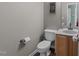 Cozy powder room with a modern granite countertop, a wood cabinet, and stylish fixtures at 300 Stobhill Ln, Holly Springs, NC 27540