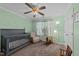 Bedroom with a baby crib, rocking horse, window, and ceiling fan creating a cozy atmosphere at 300 Stobhill Ln, Holly Springs, NC 27540