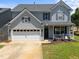 Charming two-story home with a two-car garage, a front porch and a well-maintained lawn at 300 Stobhill Ln, Holly Springs, NC 27540