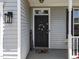 Up-close view of front door with patriotic decor and a charming covered porch at 300 Stobhill Ln, Holly Springs, NC 27540
