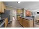 View of kitchen that connects to living room, with a large island, stainless steel appliances and wood look floors at 300 Stobhill Ln, Holly Springs, NC 27540