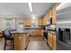 Kitchen with a large island, light wood cabinets, stainless steel appliances, and updated fixtures at 300 Stobhill Ln, Holly Springs, NC 27540
