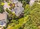 Aerial view of the property with mature trees, garden beds, stone patio, and private backyard at 315 Birdwood Ct, Cary, NC 27519