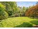 Lush backyard featuring a manicured lawn and mature trees and landscaping at 315 Birdwood Ct, Cary, NC 27519