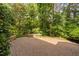 Private backyard with a spacious stone patio, stone seating, and mature trees for shade at 315 Birdwood Ct, Cary, NC 27519