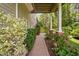 Lush backyard walkway leading to a covered patio with manicured landscaping and plants at 315 Birdwood Ct, Cary, NC 27519