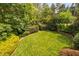 Green aerial view of private backyard with lush lawn, mature trees, and manicured landscaping at 315 Birdwood Ct, Cary, NC 27519