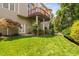 Lush backyard featuring a covered deck, manicured lawn, and thoughtfully planted landscaping at 315 Birdwood Ct, Cary, NC 27519
