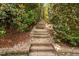 Landscaped backyard featuring stone steps leading through mature plantings and landscaping at 315 Birdwood Ct, Cary, NC 27519
