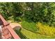 Backyard view from the deck featuring a patio and beautiful landscaping, including a variety of trees and shrubs at 315 Birdwood Ct, Cary, NC 27519