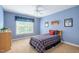 Cozy bedroom featuring a blue accent wall, a comfortable bed, and a bright window at 315 Birdwood Ct, Cary, NC 27519