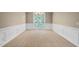 Empty dining room with neutral decor, large windows, a chandelier, and white wainscoting at 315 Birdwood Ct, Cary, NC 27519