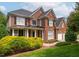 Beautiful brick two-story home with black shutters, white trim, manicured lawn, and mature landscaping at 315 Birdwood Ct, Cary, NC 27519