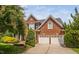 Attractive brick house featuring a two-car garage, well-maintained lawn, and colorful mature landscaping at 315 Birdwood Ct, Cary, NC 27519