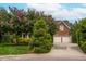 Charming brick home with a two-car garage, mature landscaping, and blooming trees enhancing curb appeal at 315 Birdwood Ct, Cary, NC 27519