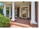 Inviting covered porch with brick flooring, white columns, and a clear view of the home's entry at 315 Birdwood Ct, Cary, NC 27519
