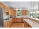 Bright kitchen features wood cabinets, floors, stainless appliances, and a window overlooking the backyard at 315 Birdwood Ct, Cary, NC 27519