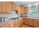 Close-up of the kitchen featuring wood cabinets, stone countertops, and modern appliances at 315 Birdwood Ct, Cary, NC 27519