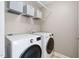 Functional laundry room equipped with front load washer and dryer and storage shelving at 315 Birdwood Ct, Cary, NC 27519