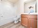 Bathroom boasts tub and shower, toilet, wooden vanity, mirror and tile flooring at 3825 Cary Glen Blvd, Cary, NC 27519