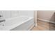 Clean, white bathtub with chrome fixtures against neutral wall and wood-look flooring at 3825 Cary Glen Blvd, Cary, NC 27519
