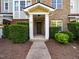 Inviting townhome entrance with brick facade, manicured shrubs, and a welcoming front door at 3825 Cary Glen Blvd, Cary, NC 27519