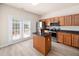 Open kitchen with island, stainless appliances, laminate flooring, and access to the outdoor deck at 3825 Cary Glen Blvd, Cary, NC 27519