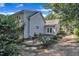 A charming backyard featuring a stone patio with a table and chairs, surrounded by lush greenery and the home's exterior at 406 E Whitaker Mill Rd, Raleigh, NC 27608