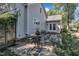 Beautiful backyard with a flagstone patio set, surrounded by lush greenery, and the charming exterior of the home at 406 E Whitaker Mill Rd, Raleigh, NC 27608