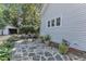 Charming backyard patio with stone paving, landscaping, and a detached garage at 406 E Whitaker Mill Rd, Raleigh, NC 27608