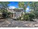 View of a home's backyard featuring a gravel area, double doors, and some greenery, nestled among mature trees at 406 E Whitaker Mill Rd, Raleigh, NC 27608
