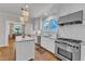 Charming kitchen featuring white cabinetry, stainless steel appliances, and modern lighting at 406 E Whitaker Mill Rd, Raleigh, NC 27608