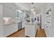 All-white kitchen featuring modern appliances, subway tile backsplash, and center island at 406 E Whitaker Mill Rd, Raleigh, NC 27608